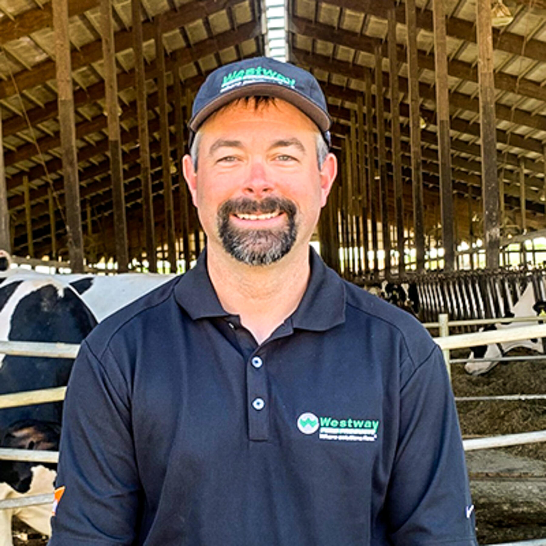 Dairy cattle nutrition expert, Dr. Andy Mueller, standing in dairy barn